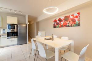 a kitchen and dining room with a white table and chairs at Hilton Beach 2BR in Tel Aviv