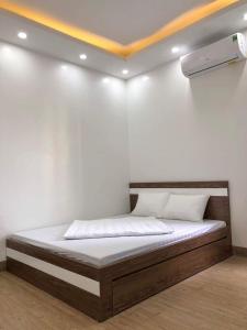 uma cama num quarto com uma parede branca em White's house em Quan Lạn