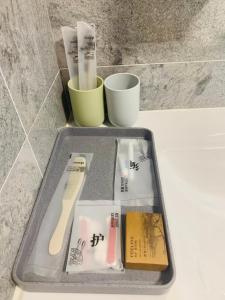 a tray with toothbrushes and cups on a counter at 【森林城市高尔夫别墅】高性价比，双层别墅民宿 in Gelang Patah