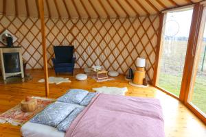 a room with a bed and a chair in a yurt at Jurtovna in Beroun