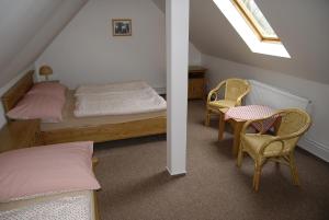 a bedroom with a bed and a table and chairs at Selský dvůr 1 in Police nad Metují