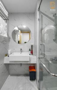 a white bathroom with a sink and a mirror at TMS View Trực Diện Biển in Quy Nhon