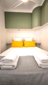 a bedroom with a large bed with yellow pillows at SUNSET GARDEN - Roof Top 45 m2 Vue Mer / Cap Canaille in Cassis