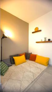 - un salon avec un canapé et des oreillers jaunes et oranges dans l'établissement SUNSET GARDEN - Roof Top 45 m2 Vue Mer / Cap Canaille, à Cassis