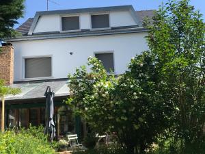 a white house with a tree in front of it at Paisible escale chez l'habitant in Vitry-sur-Seine