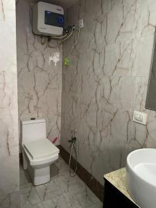 溫達文的住宿－Vrindavan Rooms，浴室配有白色卫生间和盥洗盆。