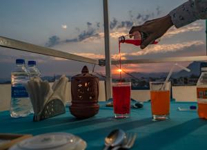 a person pouring a candle into a drink on a table at Soham Haveli - A Lake Facing Stay in Udaipur in Udaipur +78 photos
