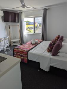a bedroom with a bed and a window in a room at PROSERPINE MOTOR LODGE in Proserpine
