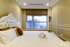 a bedroom with a large white bed with a window at Landmark 81 SHA PLUS Residence in Ho Chi Minh City