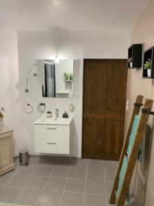 a bathroom with a sink and a wooden door at Cottage a la campagne avec piscine et SPA in Ardentes