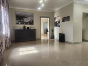 a large living room with a dresser and a hallway at Beautiful Battersea Lodge in Mandeville