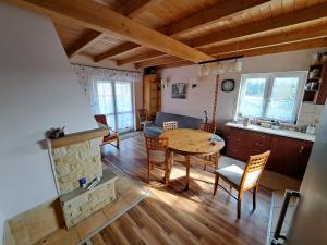 uma sala de estar com uma mesa e um sofá e uma cozinha em Dom drewniany z ogrodem em Szczecinek