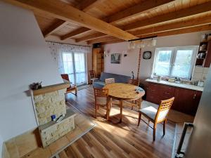 a living room with a table and a couch and a kitchen at Dom drewniany z ogrodem in Szczecinek