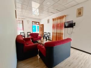 - un salon avec deux chaises rouges et une table dans l'établissement NSM Wedding hall and guest house, à Badulla