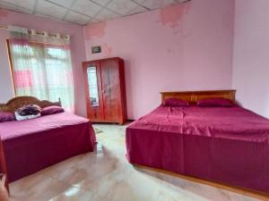 - 2 lits dans une chambre aux murs roses dans l'établissement NSM Wedding hall and guest house, à Badulla