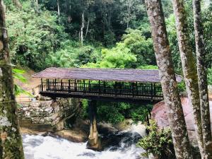 un pont sur une rivière dans une forêt dans l'établissement NSM Wedding hall and guest house, à Badulla