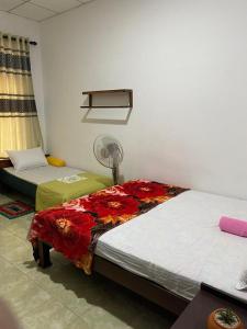 Cette chambre comprend deux lits et un ventilateur. dans l'établissement Green willa, à Badulla