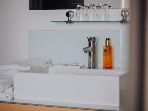 un lavabo blanco con un dispensador de jabón. en Levy's Rooms & Breakfast en Salzburgo