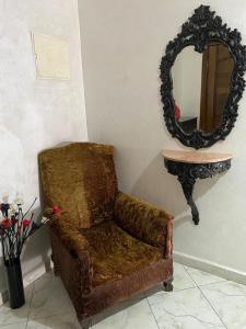 einen Stuhl im Wohnzimmer mit Spiegel in der Unterkunft Hermanos ketama hotil in Tlata Ketama
