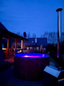 a hot tub with purple lights in front of a house at Dom Miłomłyn in Miłomłyn