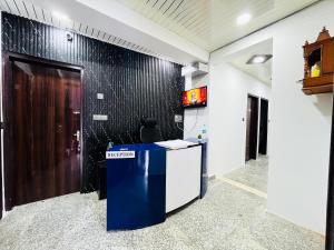 un vestíbulo con un mostrador azul y una pared negra en Roomshala 166 Hotel You Own - Vikas Puri en Nueva Delhi