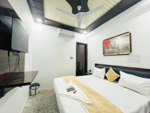 1 dormitorio con 1 cama y TV de pantalla plana en Roomshala 166 Hotel You Own - Vikas Puri en Nueva Delhi