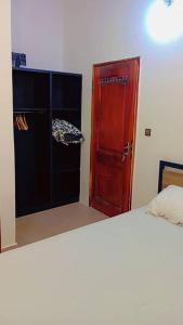 a bedroom with a bed and a red door at Appart boa in Cotonou