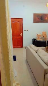 a living room with a couch and a red door at Appart boa in Cotonou