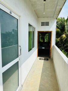 une porte ouverte d'une maison avec un balcon dans l'établissement Mallika Resort, à Mirissa