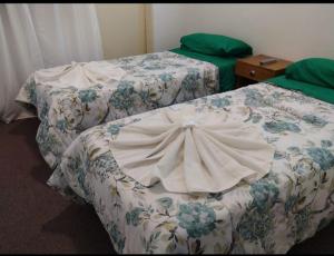 two beds in a hotel room with at Hotel Posada Sol in Villa Carlos Paz