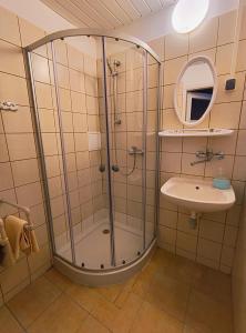 La salle de bains est pourvue d'une douche et d'un lavabo. dans l'établissement Pokoje Dom Turysty Sanok 24h, à Sanok