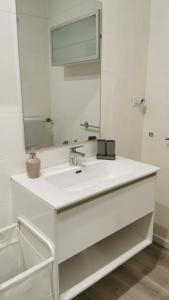 a white bathroom with a sink and a mirror at Madama Suite in Turin