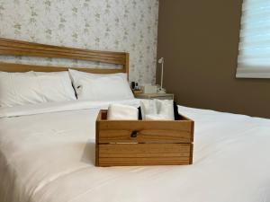 - un lit avec une boîte en bois et des serviettes dans l'établissement Deer Tea B&B, à Longtian
