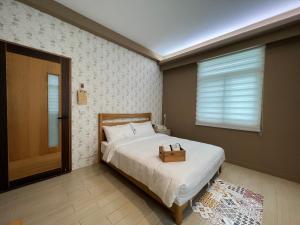 Un dormitorio con una cama con una caja de madera. en Deer Tea B&B en Longtian