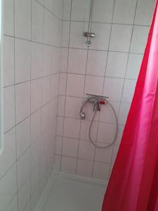 a bathroom with a shower with a red shower curtain at Apartment Villa Nähe Bahnhof in Heide
