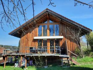 ein großes Holzhaus mit einem großen Fenster in der Unterkunft Musik und Natur - Balboo - Bayrischer Wald - Sauna - Pool - Grillen in Spiegelau