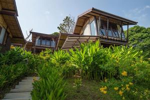 une maison avec un escalier en face d'un jardin dans l'établissement Alama Sea Village Resort - SHA Extra Plus, à Ko Lanta