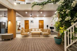 a living room with a couch and chairs on a porch at Tirta Spring Villa (5br) Vacation House in Los Baños