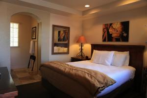 
a bedroom with a large bed and a painting on the wall at The Lodge on Route 66 in Williams

