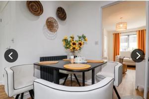 a dining room with a black table and white chairs at Captains Quarters in Charlestown