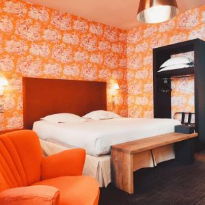 a bedroom with a bed and a table and a chair at Hôtel de Paris in Besançon