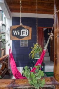 un signo que lee wfd colgando de una mesa con plantas en Hostel El Gran Azul Olon, en Olón