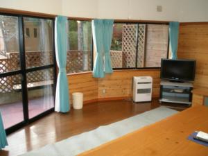 a living room with blue curtains and a television at Lake Kawaguchi Rental Villa Tozawa Center - Vacation STAY 46845v in Oishi