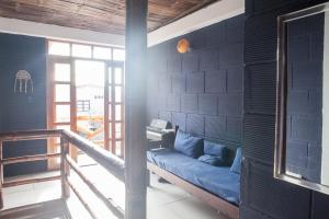 a living room with a blue couch against a wall at Hostel El Gran Azul Olon in Olón