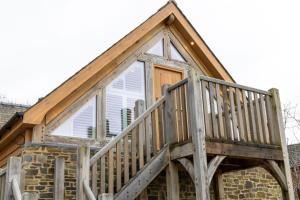 a house with a wooden deck on top of it at Plas Robin in Llandyssil