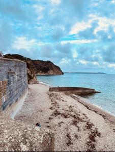 a beach with a stone wall and the ocean at Captains Quarters in Charlestown
