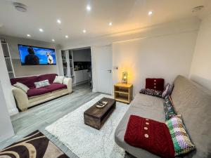 a living room with a couch and a table at 1 Bedroom Flat with whirlpool bath in London