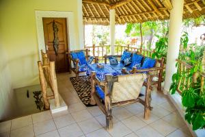 a patio with a table and chairs on a porch at 3 Bed Villa Sleeps 6 - Pool Garden Chef Option in Diani Beach