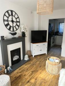 a living room with a fireplace and a large clock at Captains Quarters in Charlestown