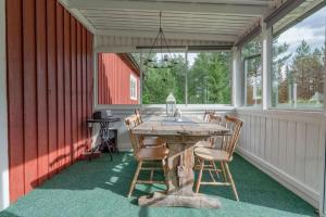 a screened in porch with a wooden table and chairs at Nära fjäll och natur! in Vemhån +33 photos